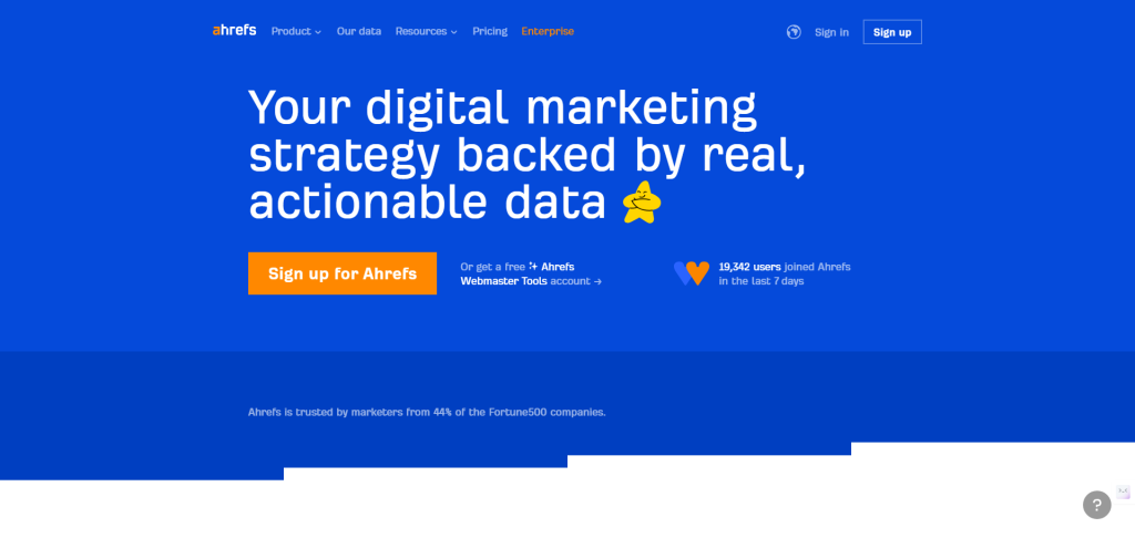 Ahrefs homepage with a blue background. Text promotes digital marketing strategies with real, actionable data. Includes a call-to-action button to sign up and a note on recent user sign-ups.